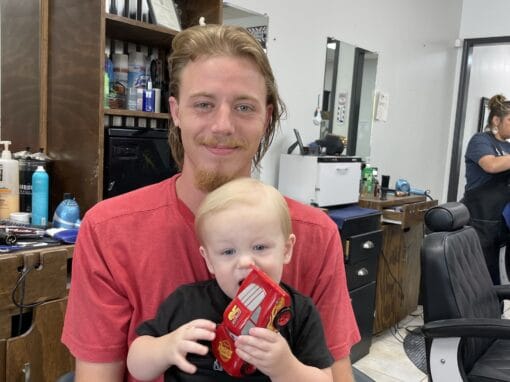 JD Barber Shop Magnolia TX Photo Gallery Relaxed man and child at JD Barber Shop, classic barber salon for men's grooming.